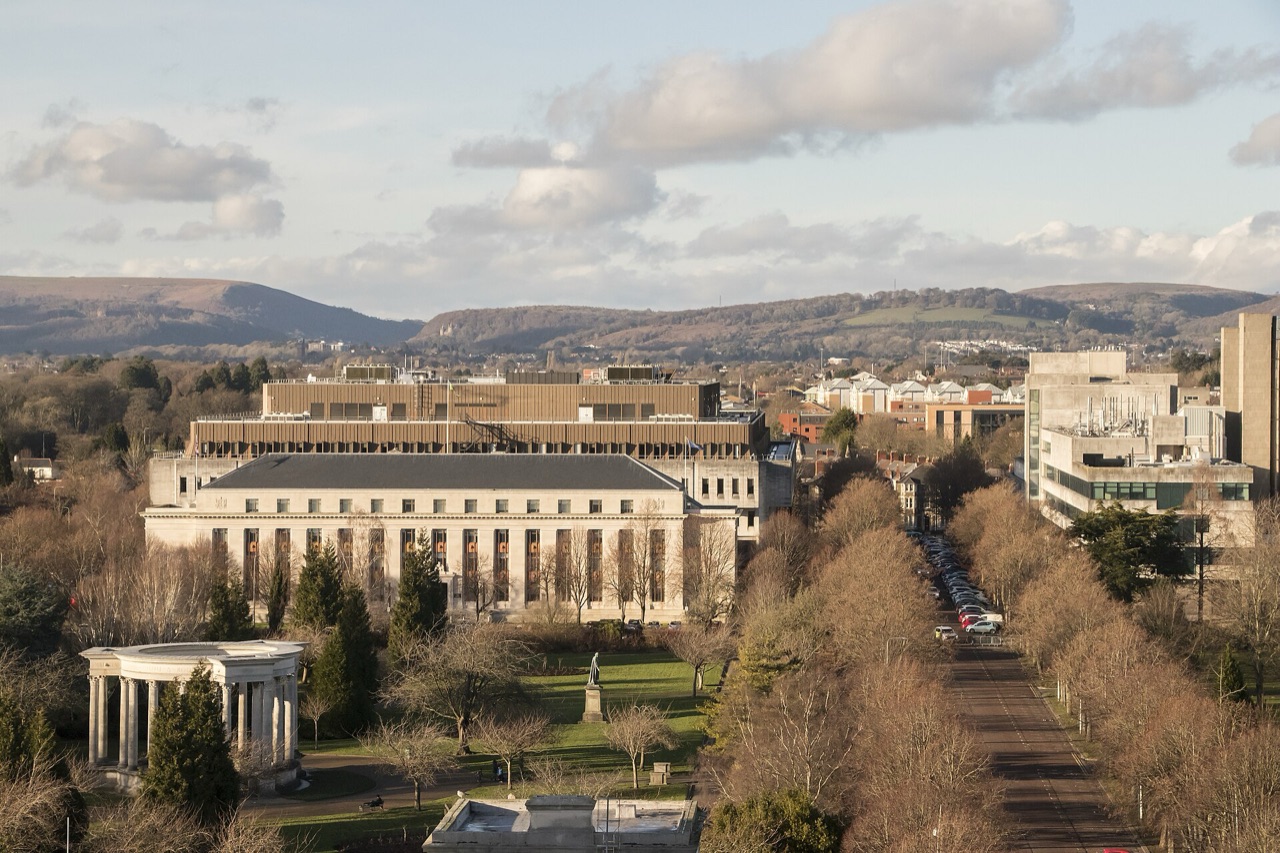 An elevated view north over Cathays Park in Cardiff, with civic buildings, a tree-lined avenue and hills beyond