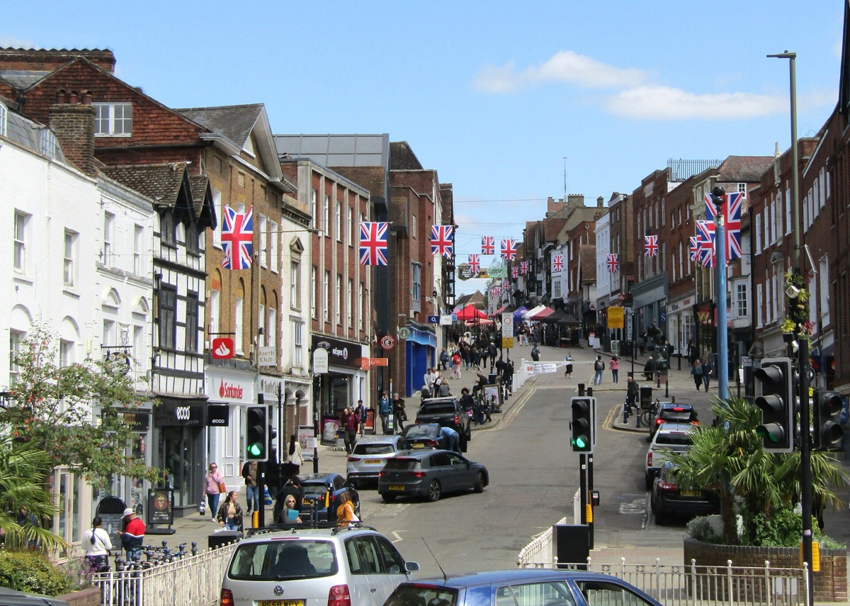 Guildford High Street sloping downhill, lined with shops and hung with bunting