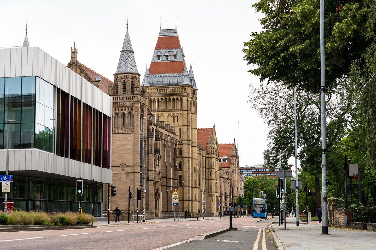 Oxford Road in Manchester, with the Victorian Gothic University of Manchester buildings beside a modern glass building