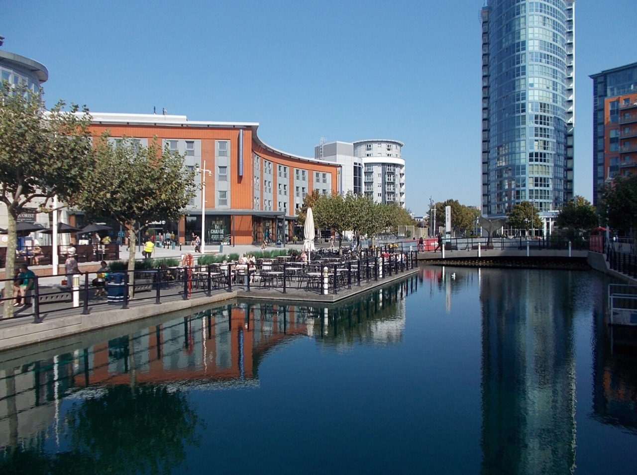 The waterside at Gunwharf Quays in Portsmouth, with cafe terraces and buildings reflected in the water