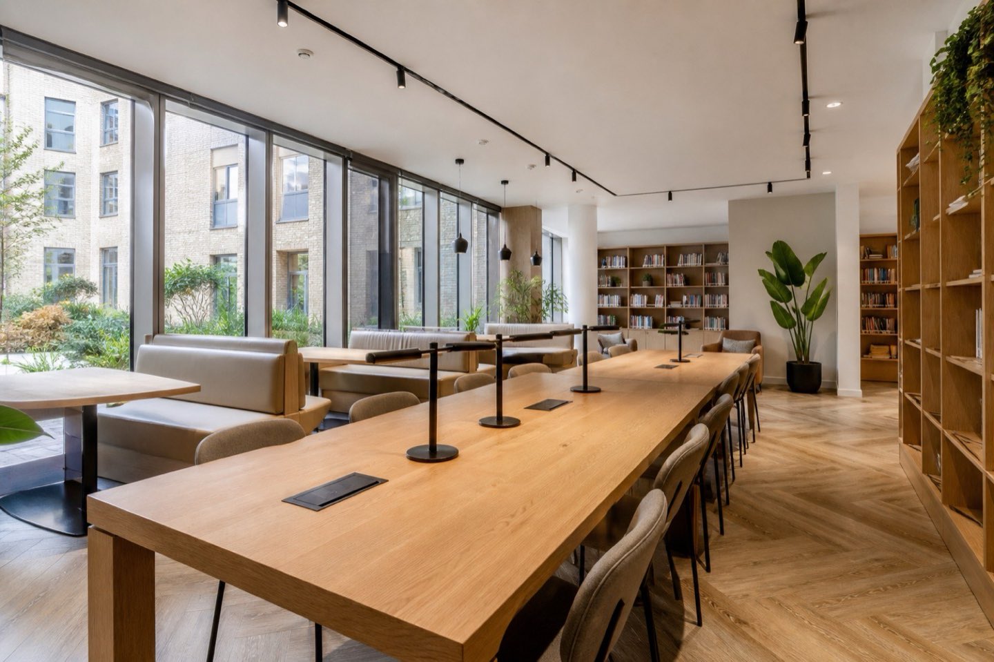 A shared study space with long oak tables in a student building